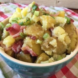 mayo free potato salad with bacon and green onions on a checkered tablecloth