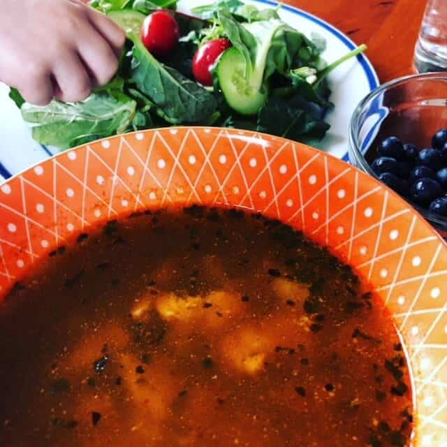 bowl of white chicken chili with mixed green salad