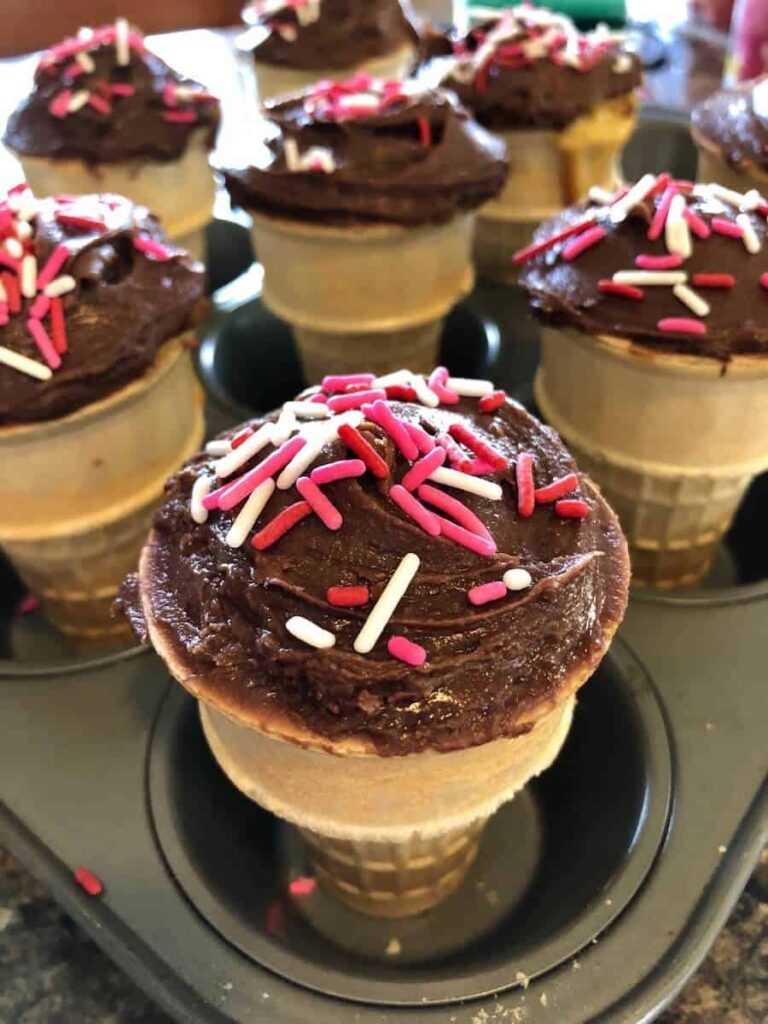Ice cream cone cupcakes placed in a muffin tin for serving.