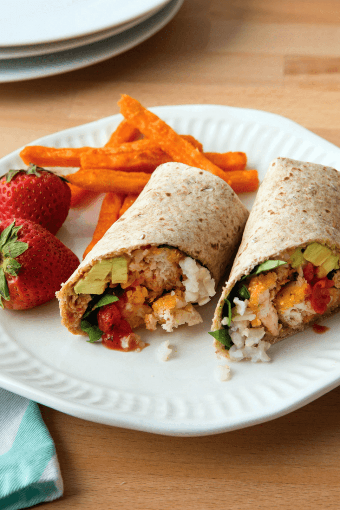 Chicken nugget burritos with strawberries and sweet potatoes on the side.