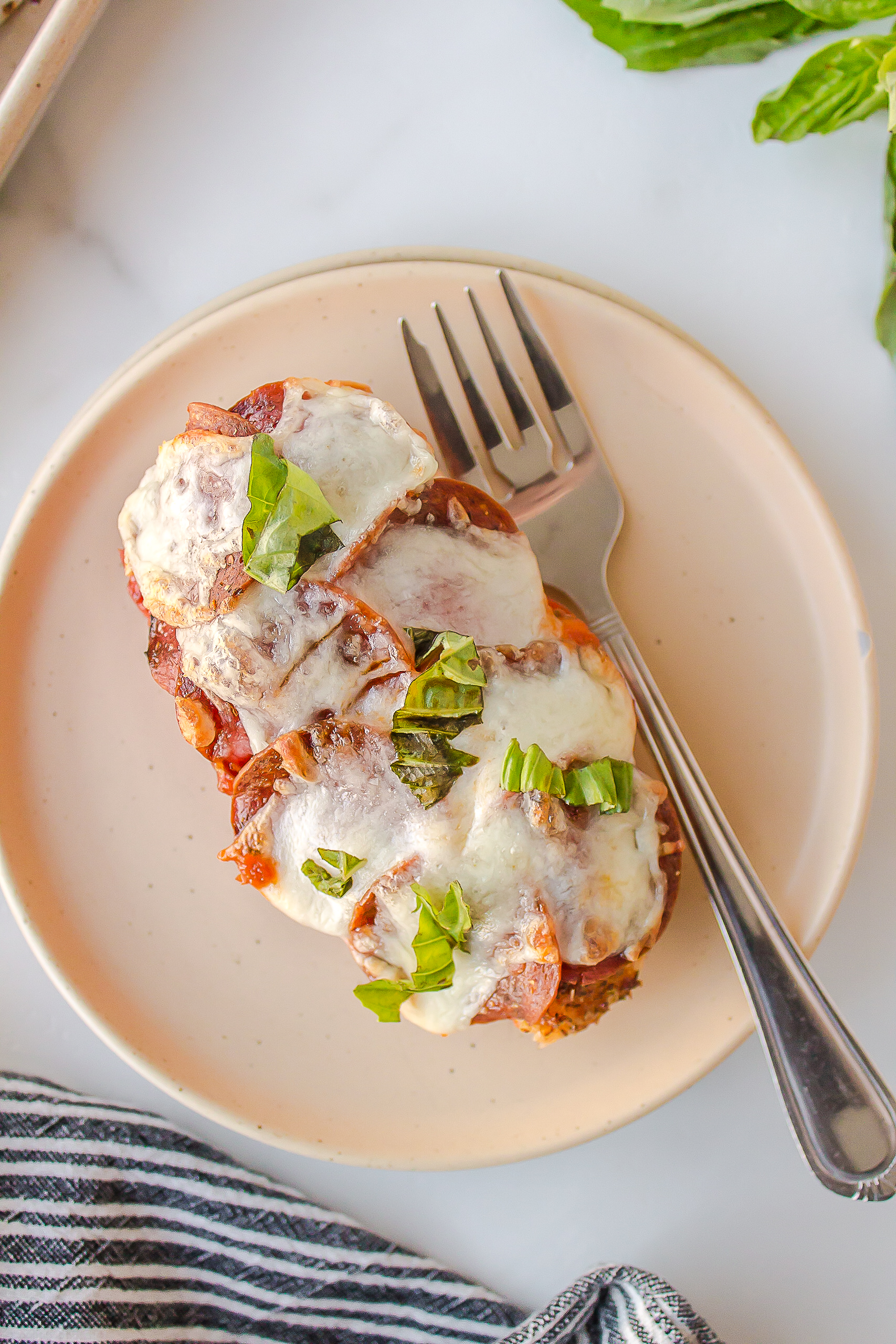 Chicken breast covered with cheese, pepperoni and chopped basil.