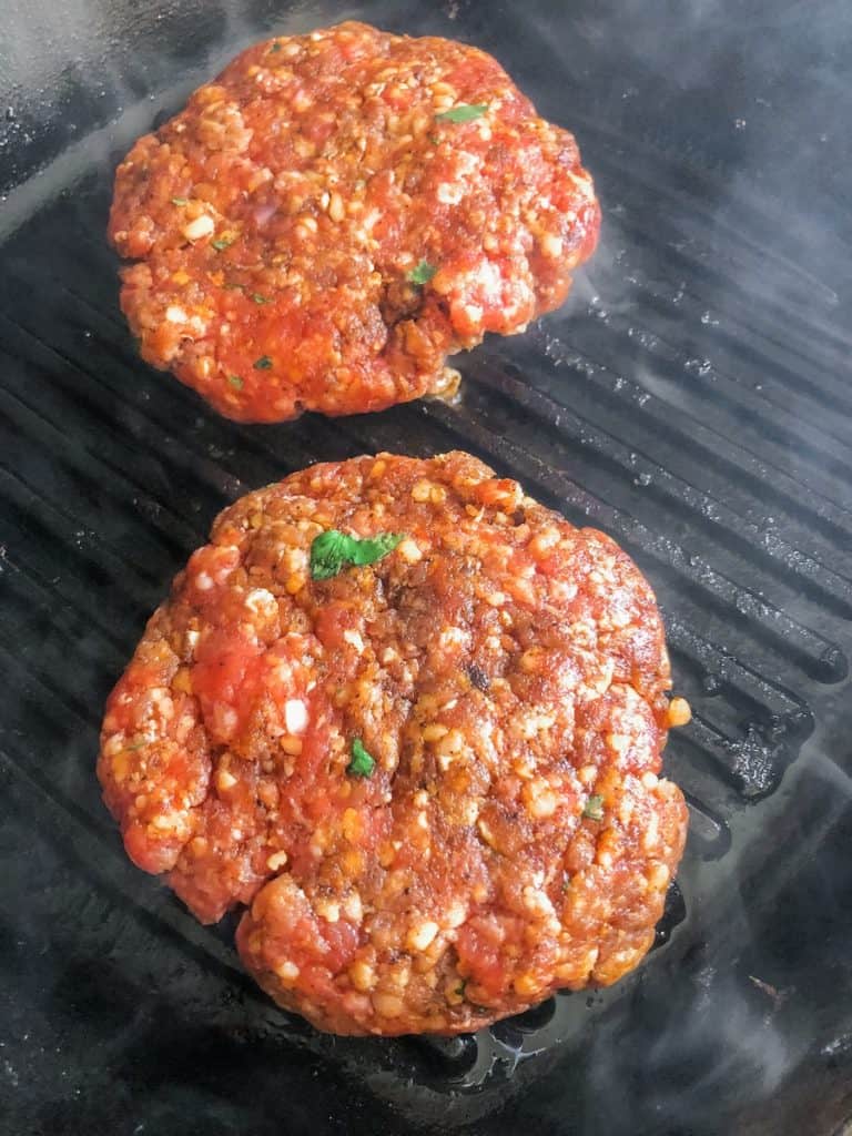 ground beef on a grill with spices and cilantro
