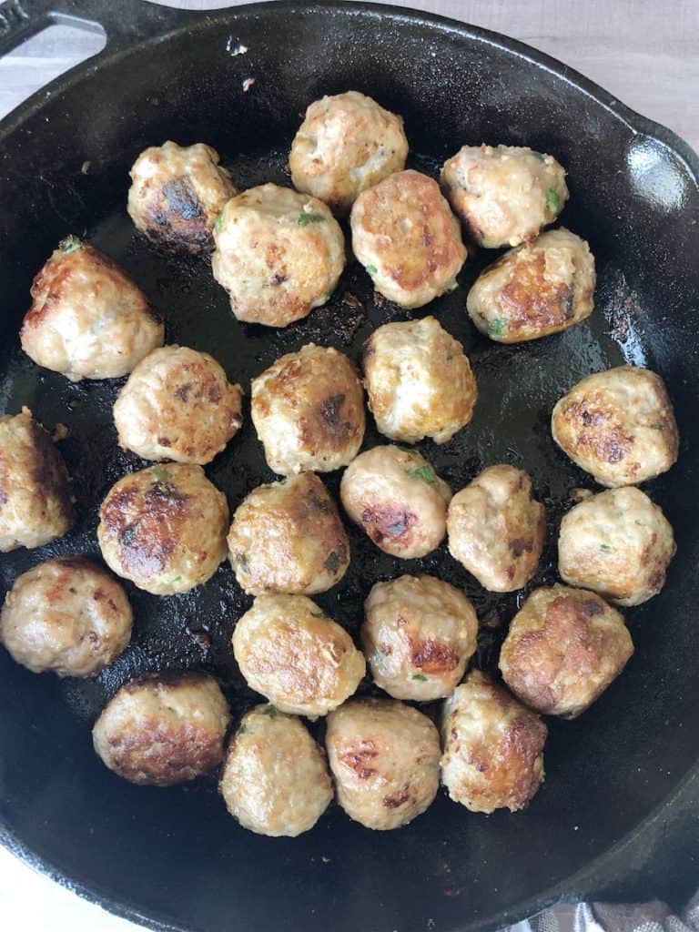 sweet and sour pork meatballs in a cast iron skillet