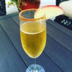 champagne flute of apple cider mimosa