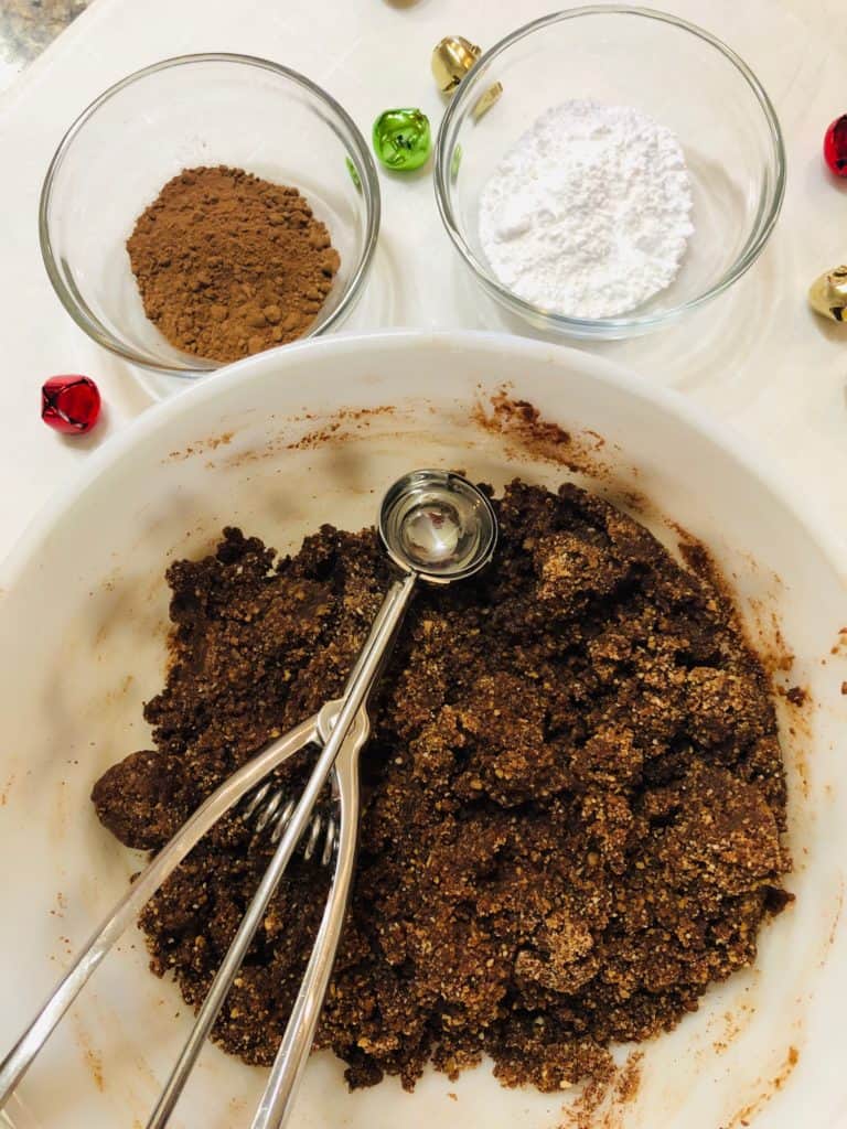 A chocolate mixture in a bowl with a cookie scoop.