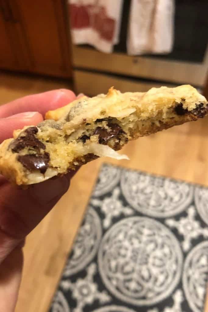A chocolate chip cookie with a bite taken out.