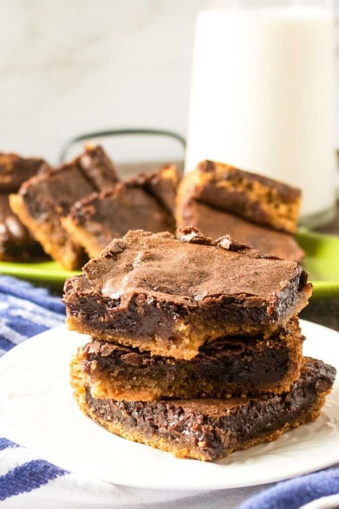 A stack of chocolate peanut butter brownies on a plate.
