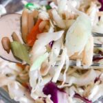 A bowl full of cabbage salad with ramen noodles.