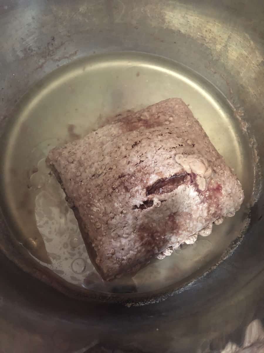 Partially thawed ground beef in an instant pot before sauteeing.