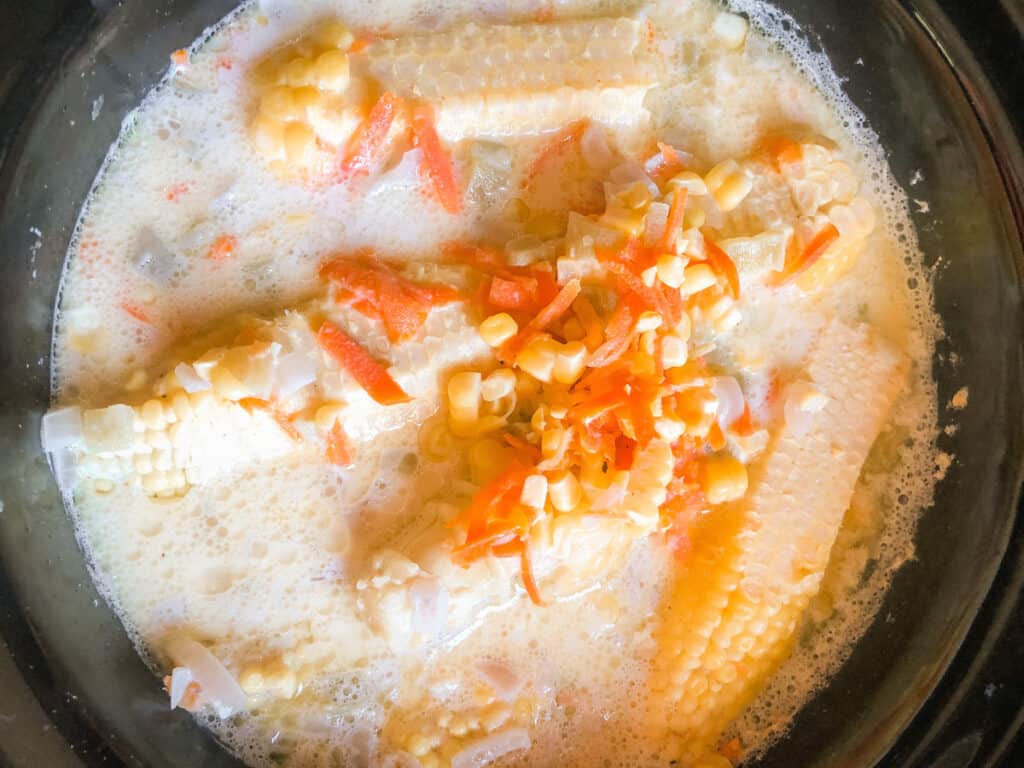 Corn cobs, carrots and corn in a crockpot.