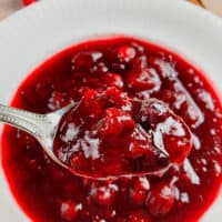 Make-ahead cranberry sauce in a white bowl with fresh cranberries on top.