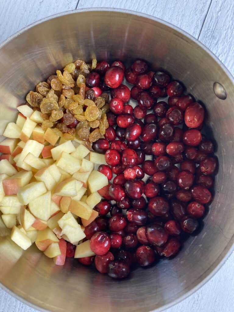 cranberries, apples and golden raisins in a saucepan