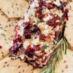 A goat cheese log coated in dried cranberries and pecans with rosemary.