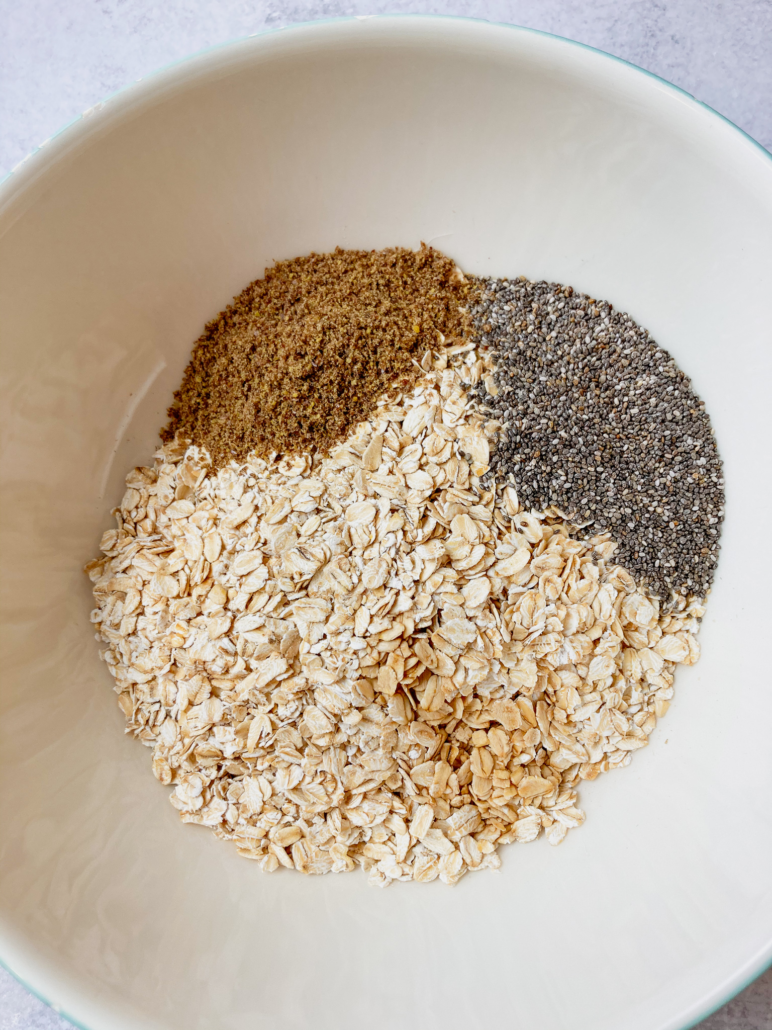 Rolled oats, flax seed, chia seed in a bowl to make a healthy oatmeal bites.