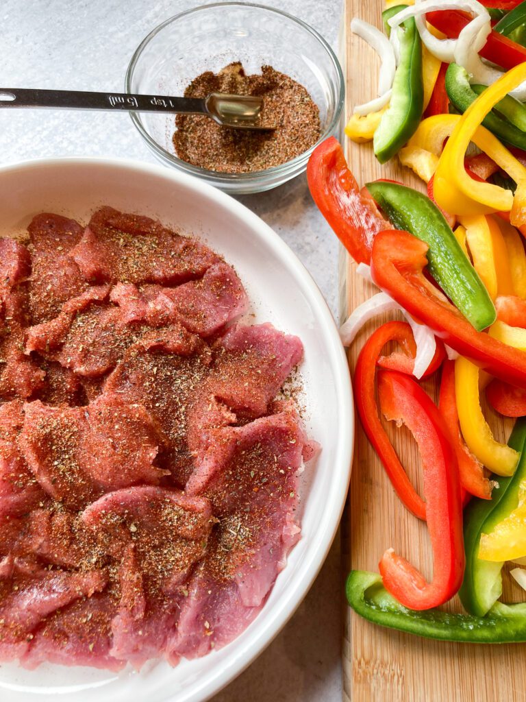 pork tenderloin sliced for fajitas with onions and peppers