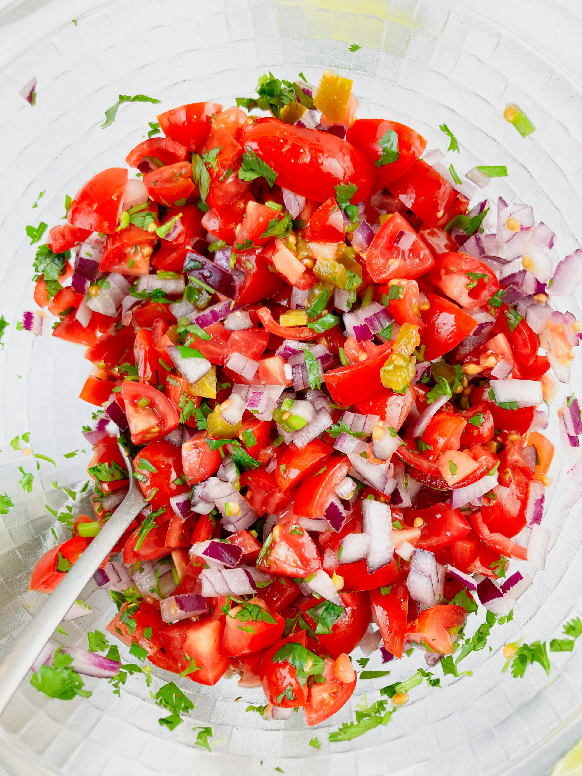 A bowl of pico de gallo with red onions.