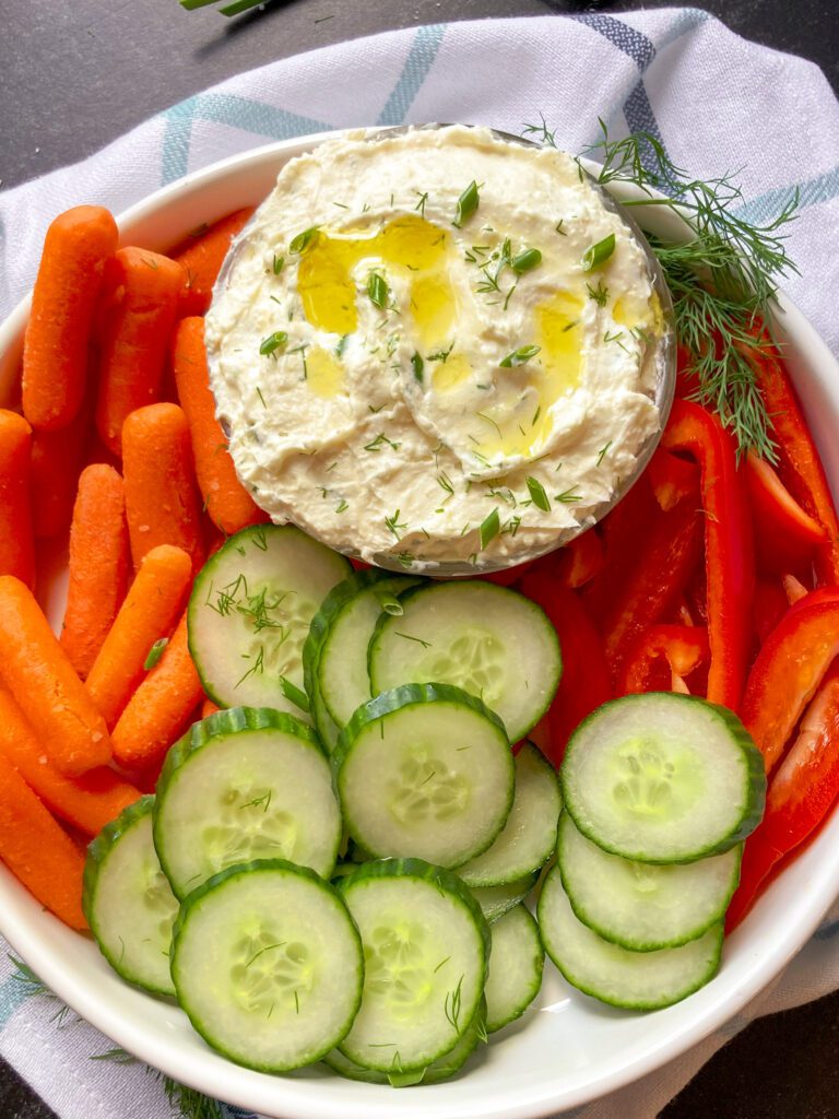 whipped feta dip on a serving dish  with fresh veggies