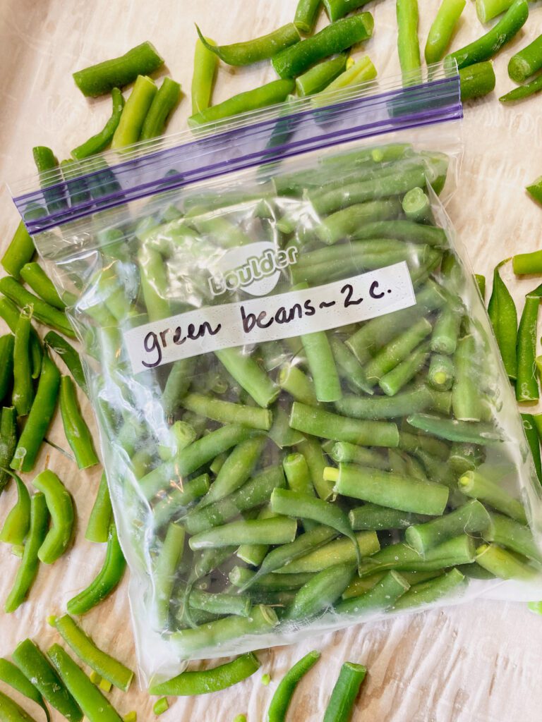 A freeze bag filled with 2 cups of green beans to be frozen.