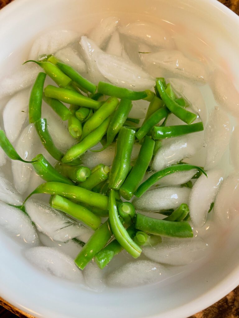 Cut fresh green beans in ice water.
