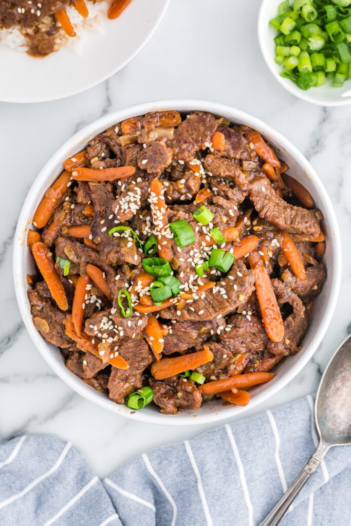 Instant pot mongolian beef strips with baby carrots and green onion.