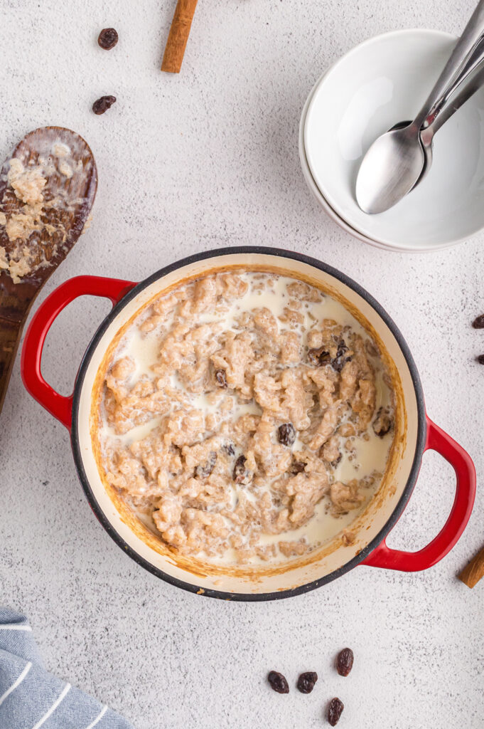 Baked rice pudding in a casserole dish topped with heavy cream.