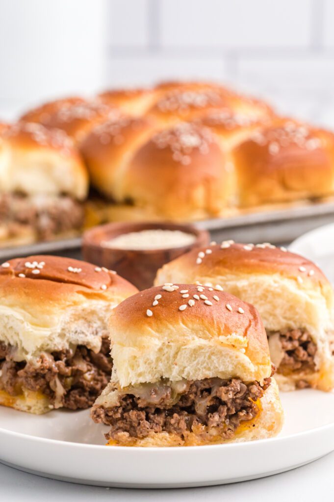Cheeseburger sliders on Hawaiian rolls topped with sesame seeds.