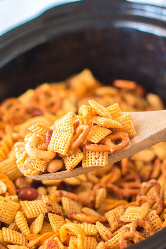 chex mix on a wooden spoon