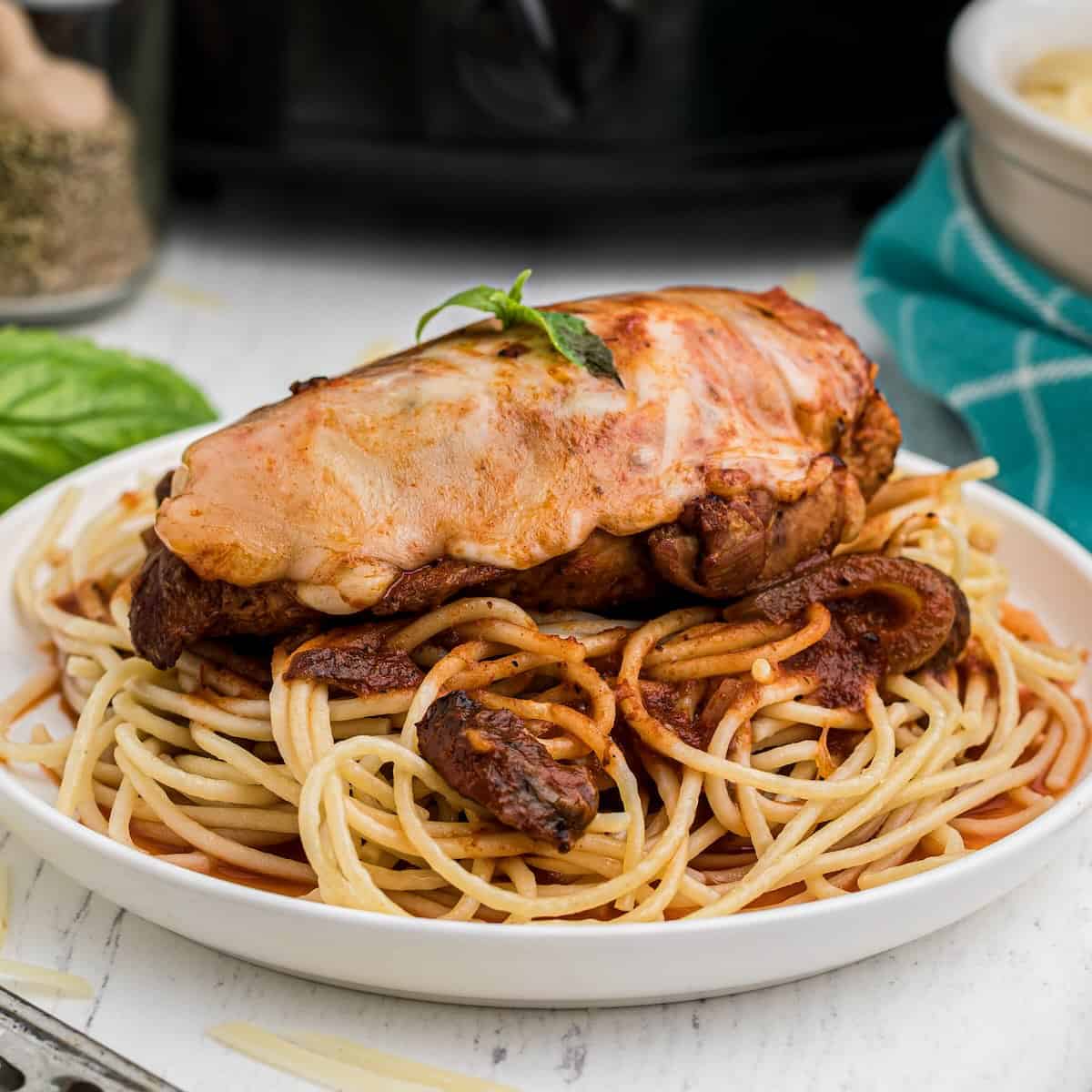 Crockpot Chicken Parmesan served over spaghetti.