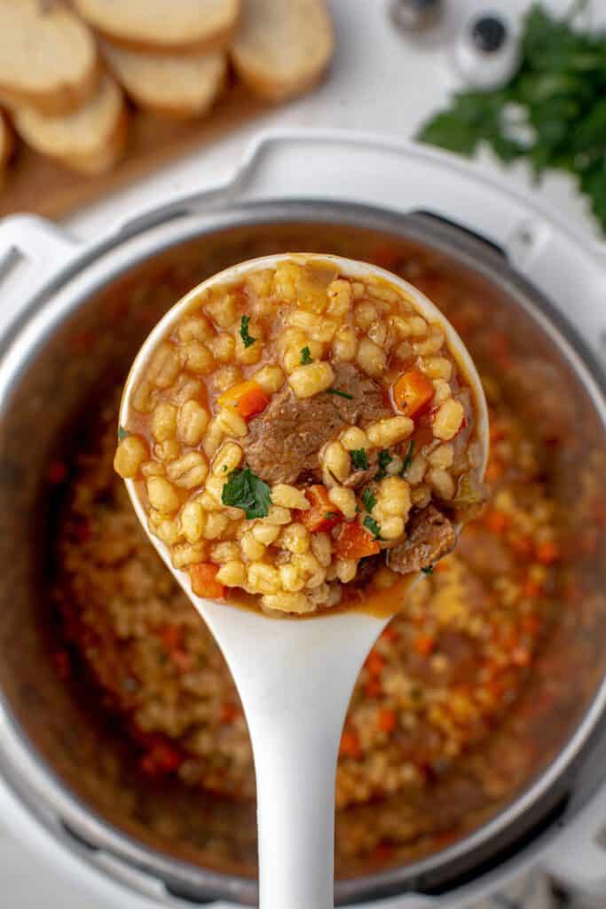 beef barley soup on a serving spoon