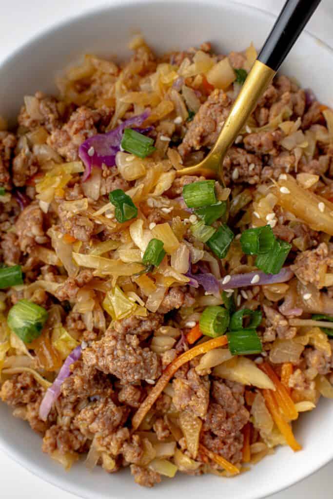 Cooked cabbage, carrots, green onions, sesame seeds and soy sauce with ground pork.