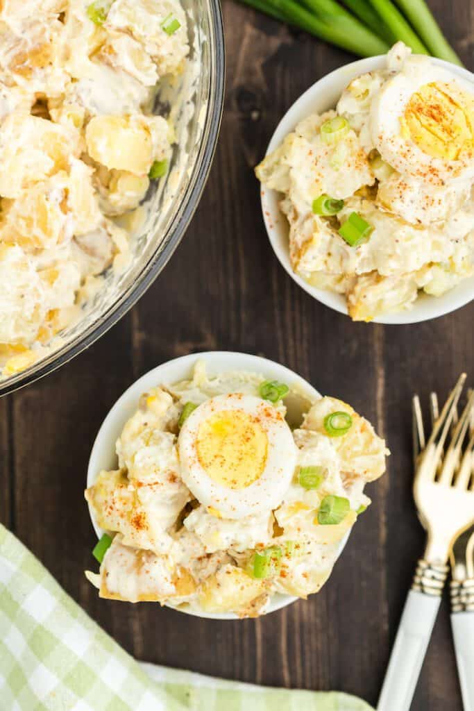 Sour cream potato salad topped with a hard boiled egg slice.