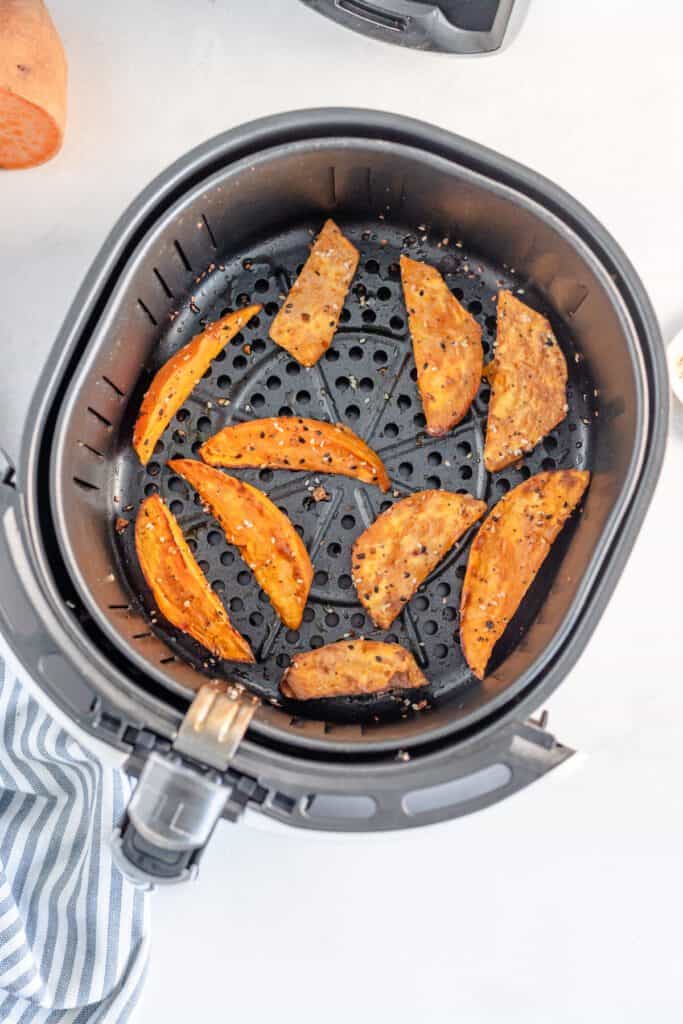 Cooked sweet potatoes in an air fryer basket.