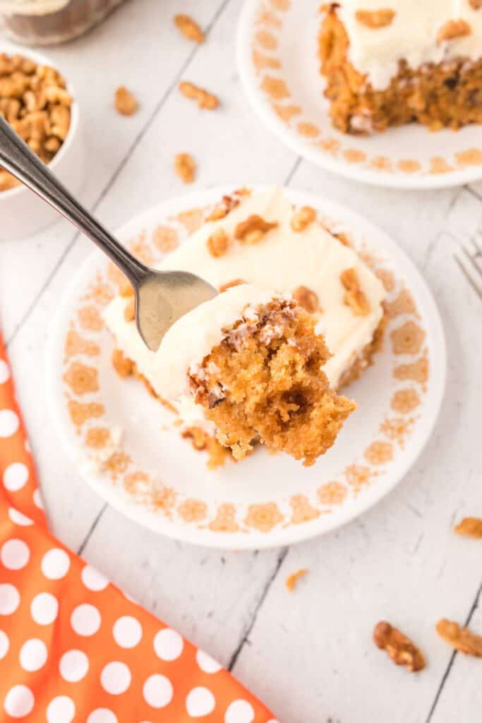 fork full of carrot cake with cream cheese frosting