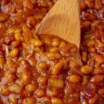 Baked pork and beans with a wooden spoon.