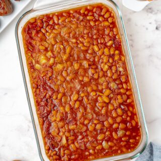 pan of baked beans with bacon and brats