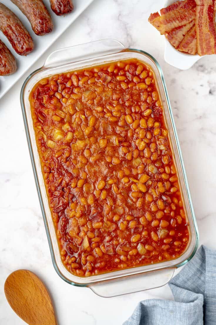 pan of baked beans with bacon and brats