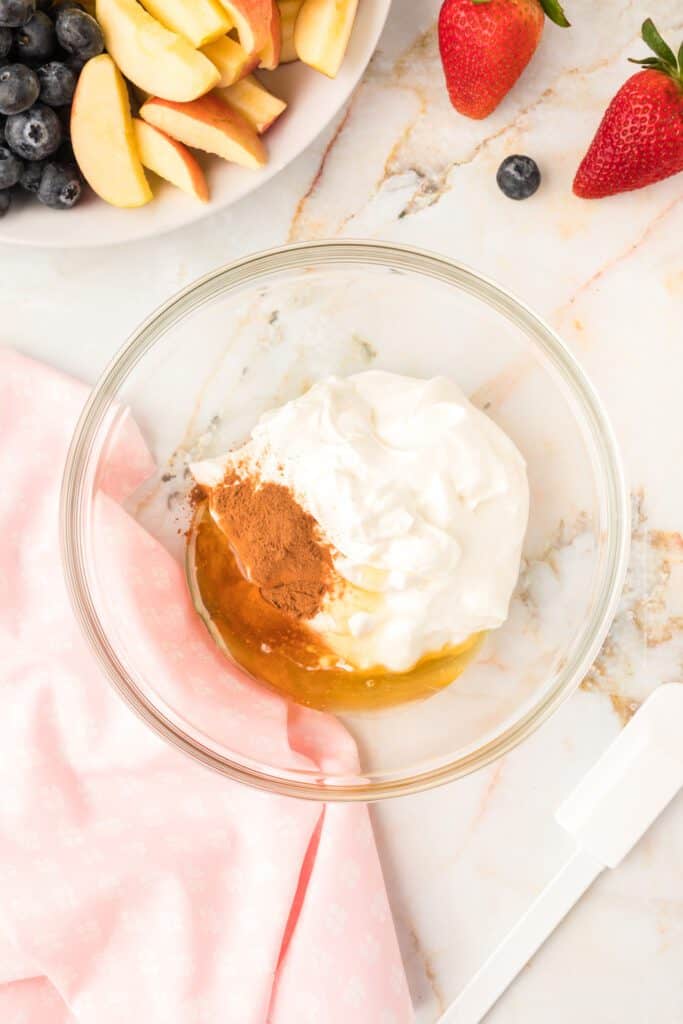 greek yogurt, honey and cinnamon in a clear glass bowl.