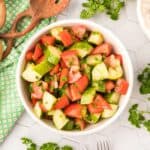 Tomatoes, cucumber and parsley in a salad bowl.