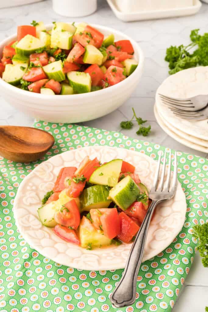cucumber tomato salad on a plate with a fork