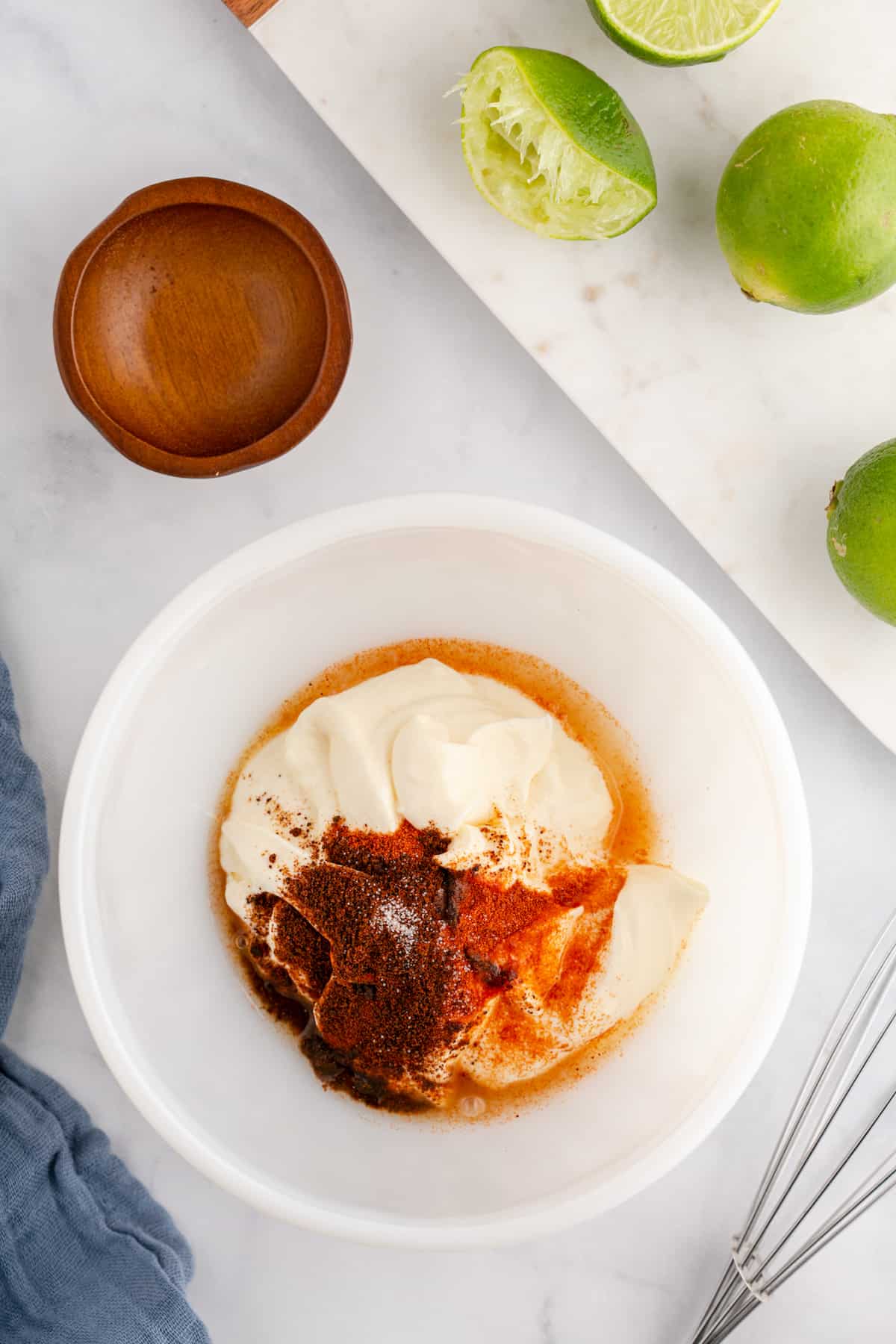 All the ingredients to make chipotle mayonnaise in a bowl, ready to mix.