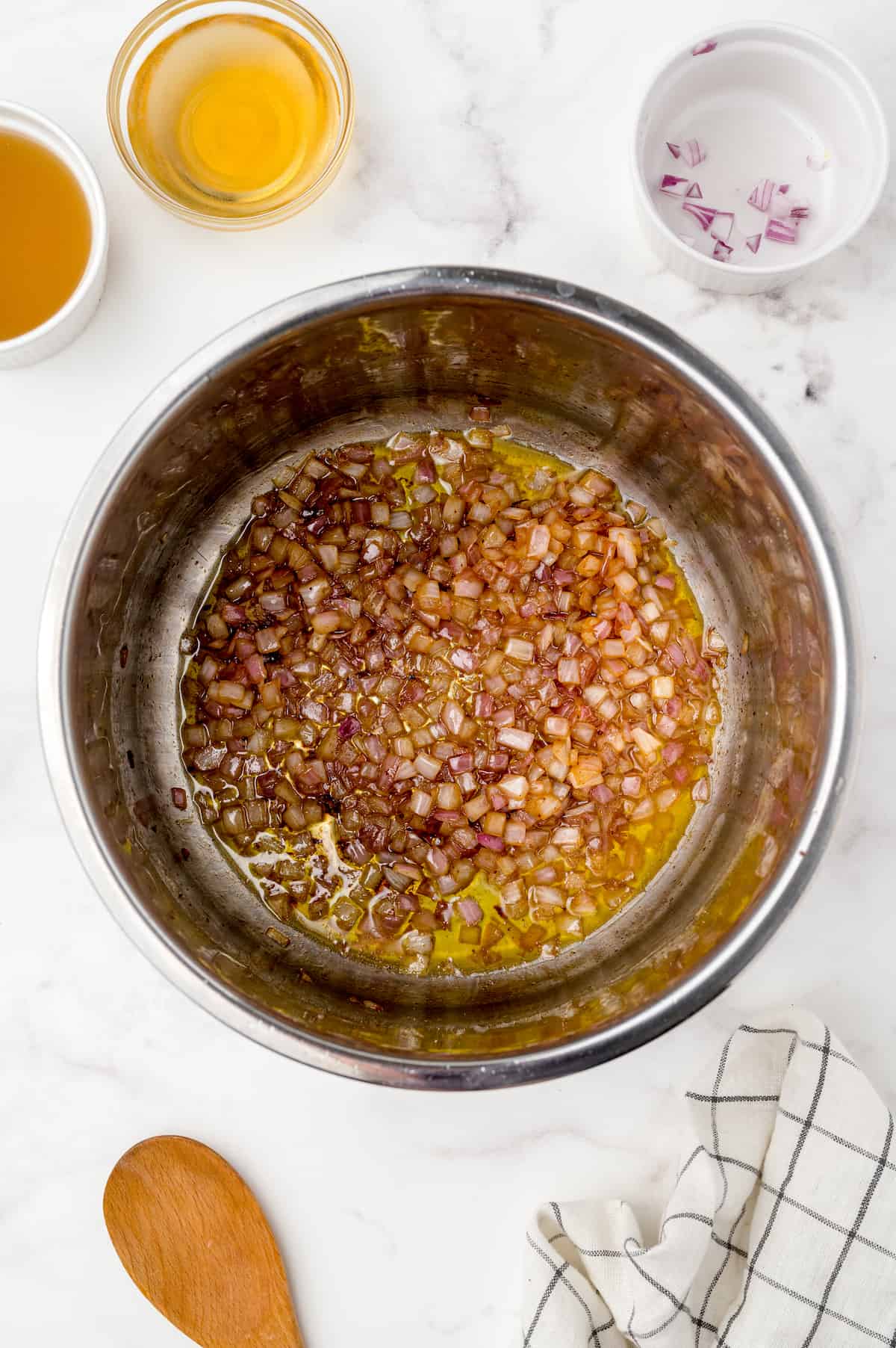 Chopped onions cooking in the Instant Pot with flavorful browned bits on the bottom.
