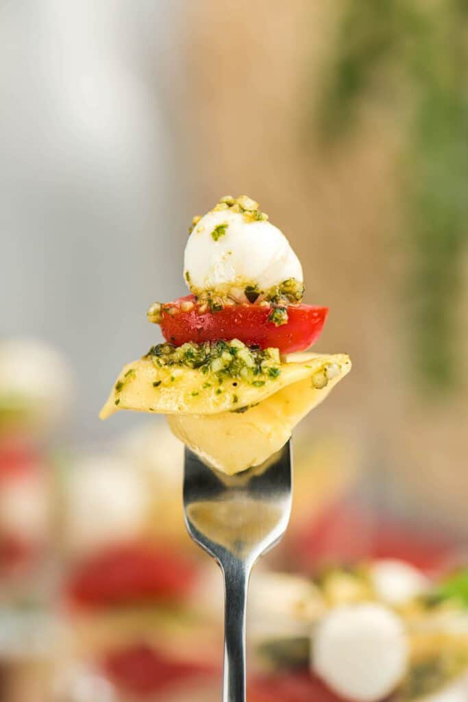 Tortellini caprese salad on a fork.