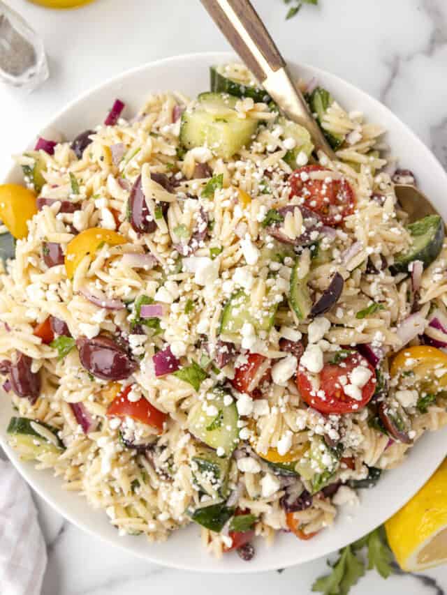 Green Lemon Orzo Salad in a large bowl with a spoon.