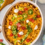 A warm walking taco casserole topped with sour cream and fresh jalapeno slices.