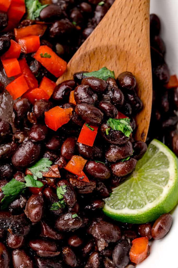 Mexican black beans on a wooden spoon.