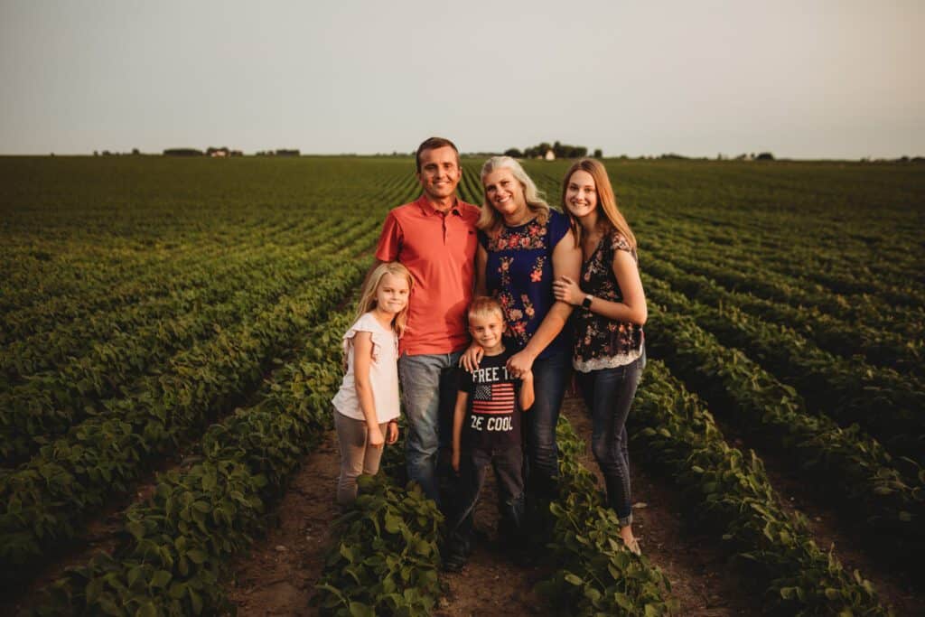 Standing in a row of growing soybeans with family.