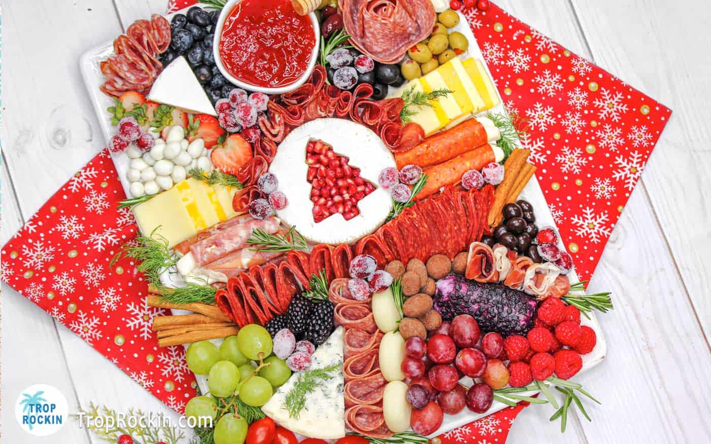 Brie with pomegranate seeds, meats, cheeses and fruits.