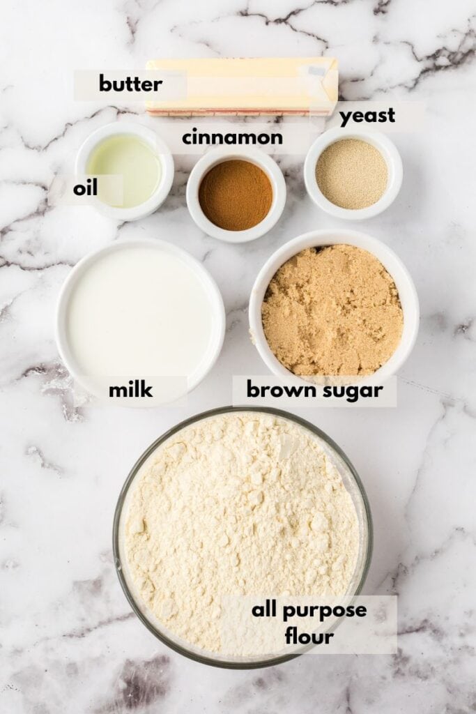 Ingredients in cinnamon roll muffins including flour, yeast, milk, cinnamon, butter, cinnamon, oil and yeast.