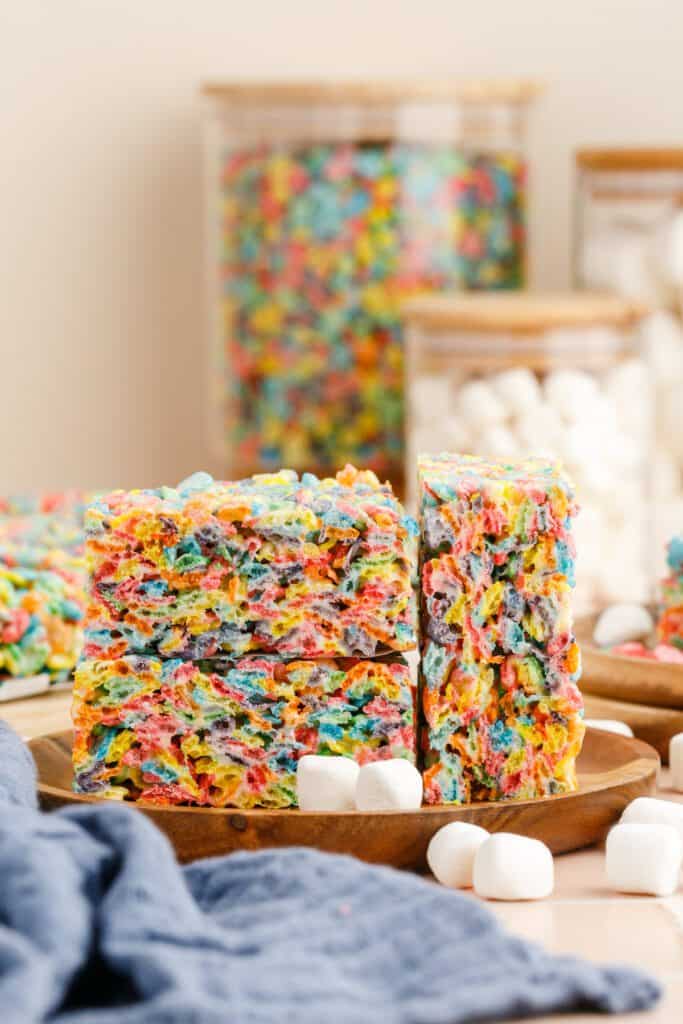 Stacked fruity pebble treats on a plate.