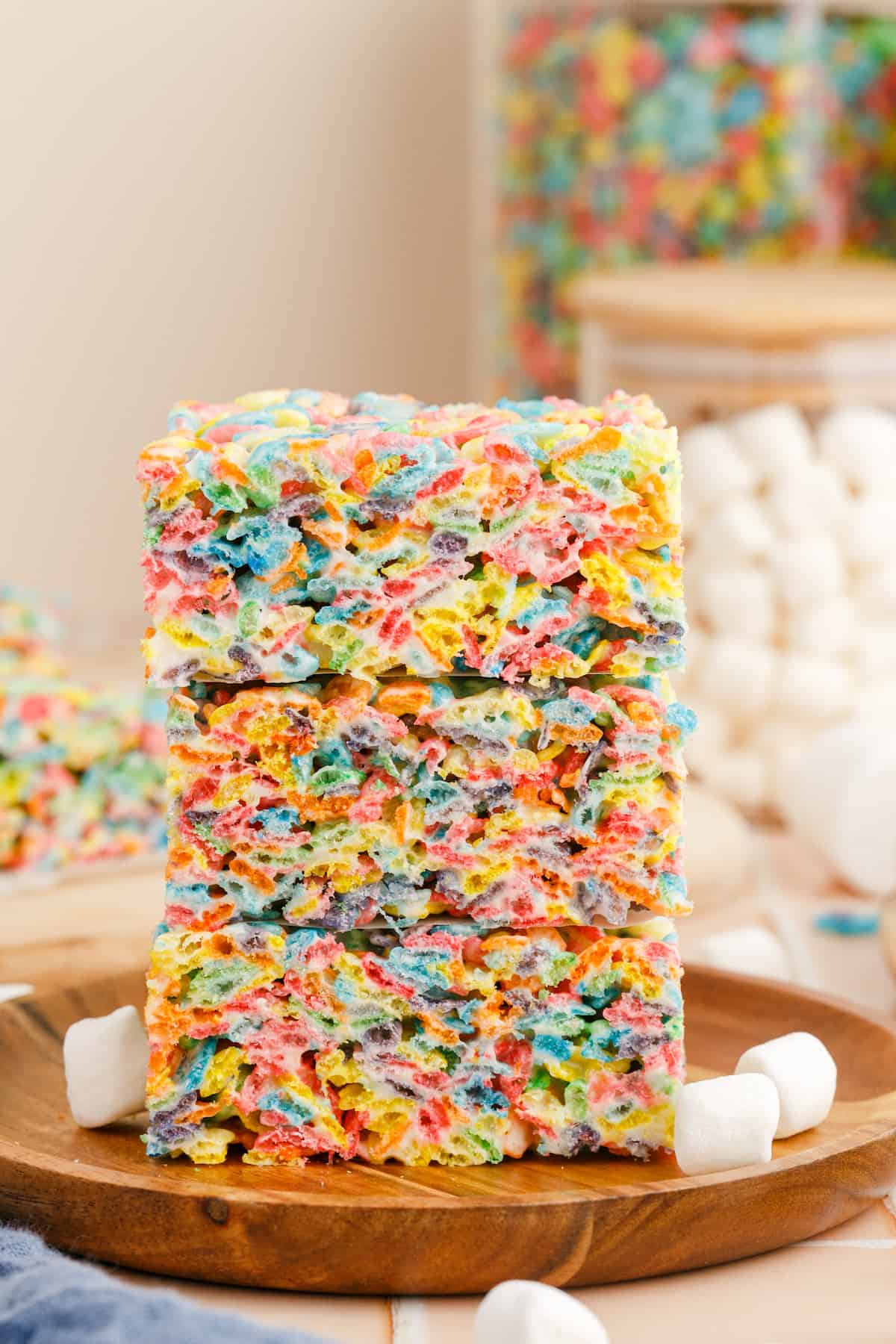 A stack of fruity pebbles treats surrounded by mini-marshmallows.